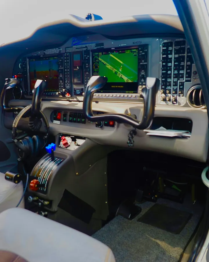 Flight deck of a business aircraft with twin control yokes and glass displays